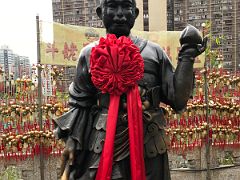02B Year of the Monkey Chinese Zodiac statue wearing a red sash scarf near the entrance to Wong Tai Sin temple Hong Kong